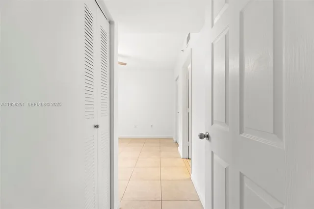 an empty room with windows and ceiling fan