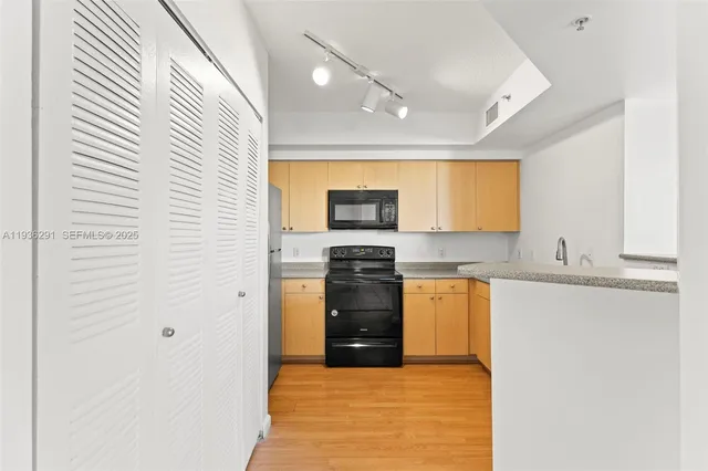 a kitchen with stainless steel appliances granite countertop white cabinets and window