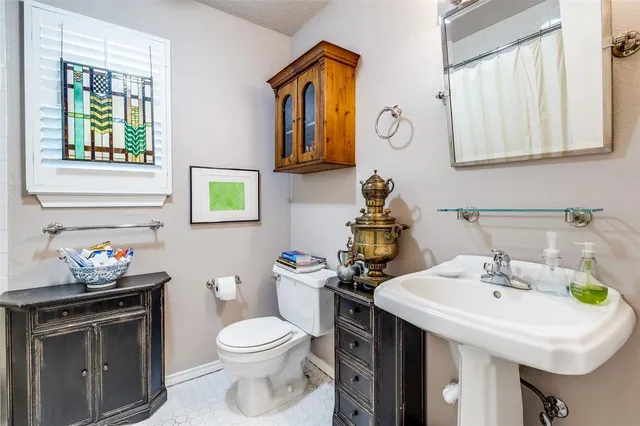 a bathroom with a sink a toilet and a mirror