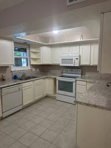 a kitchen with stainless steel appliances granite countertop a sink and a stove