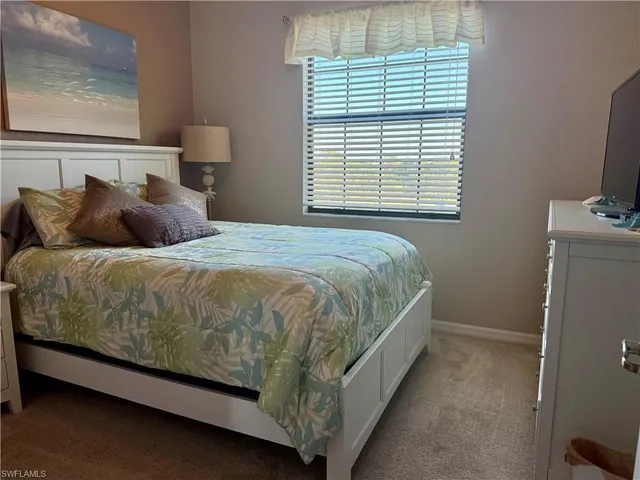 a large bed sitting in a bedroom next to a window