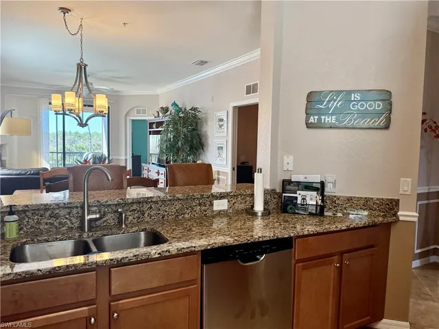 a very nice looking kitchen with granite countertop a sink a stove and a wooden floors