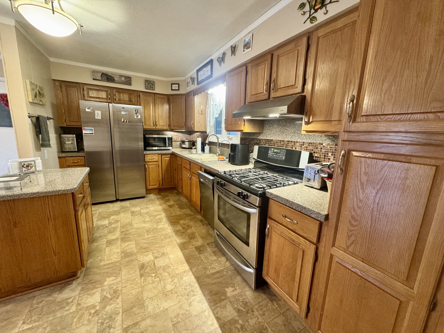 206 East Warren Street Le Roy, IL 61752 - Photo 7 of 18 a kitchen with stainless steel appliances granite countertop a refrigerator a stove and a sink