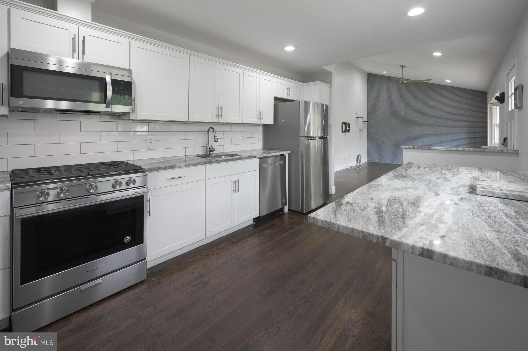 a kitchen with stainless steel appliances granite countertop a stove a refrigerator and a microwave