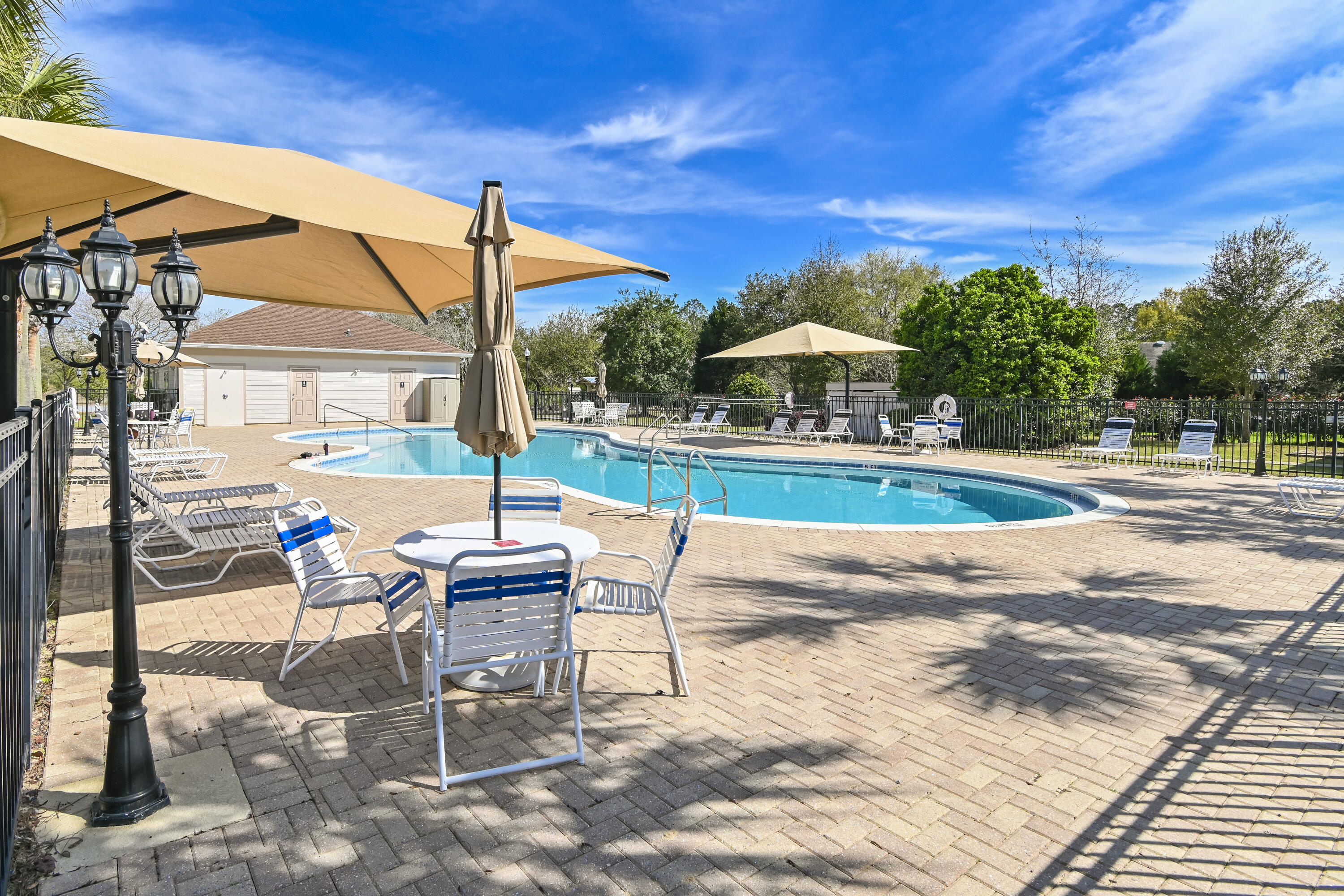 379 Fairway Crossing Freeport, FL 32439 - Photo 26 of 32 a patio with a table and chairs under an umbrella