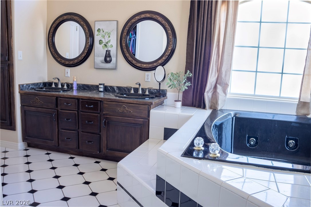 2775 Taylor Street Logandale, NV 89021 - Photo 8 of 41 This bathroom offers dual vanities and a soaking tub with an arched window.