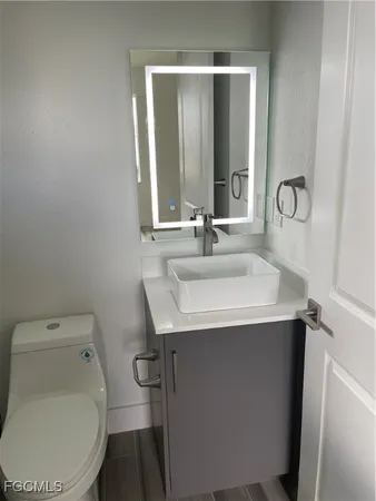 a bathroom with a sink toilet and mirror