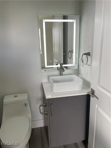 a bathroom with a sink toilet and mirror