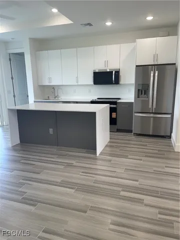 a kitchen with stainless steel appliances granite countertop a refrigerator sink and cabinets