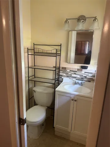 a bathroom with a toilet sink and mirror