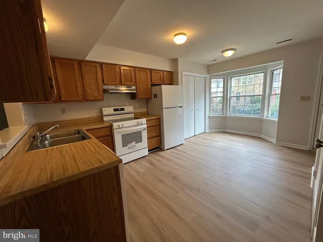 a kitchen with granite countertop a stove top oven and cabinets