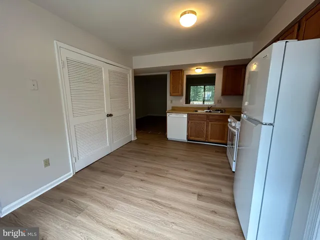 a view of kitchen with refrigerator stove and wooden floor