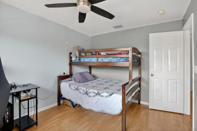 a bedroom with a bed and wooden floor