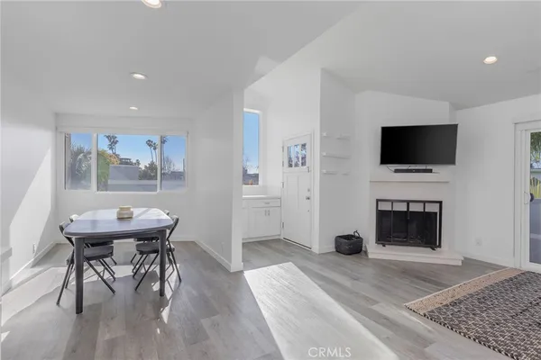 a living room with a fireplace a flat screen tv and a rug