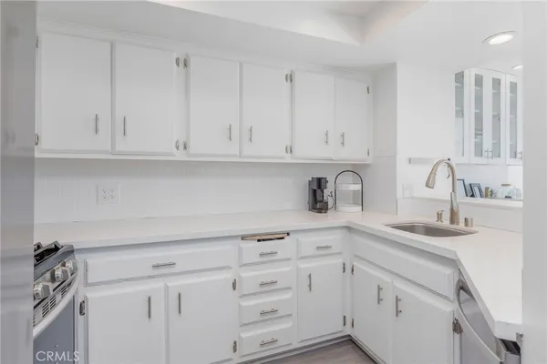 a kitchen with white cabinets and a sink