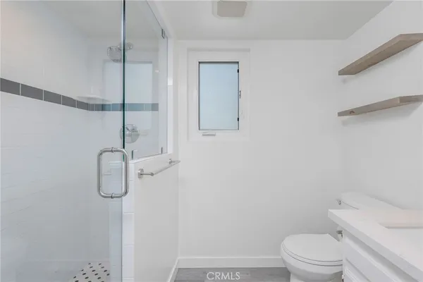 a bathroom with a granite countertop sink toilet a mirror and shower
