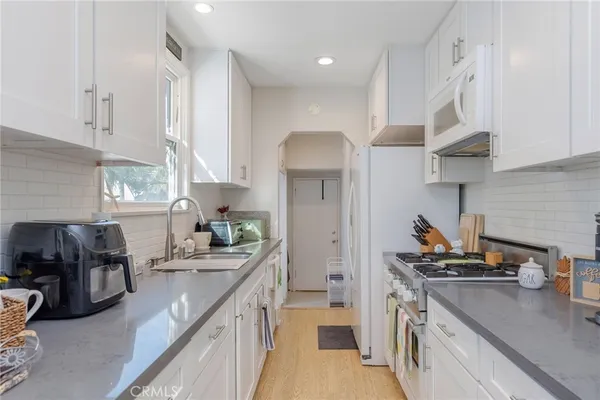a kitchen with kitchen island granite countertop a sink stove and cabinets