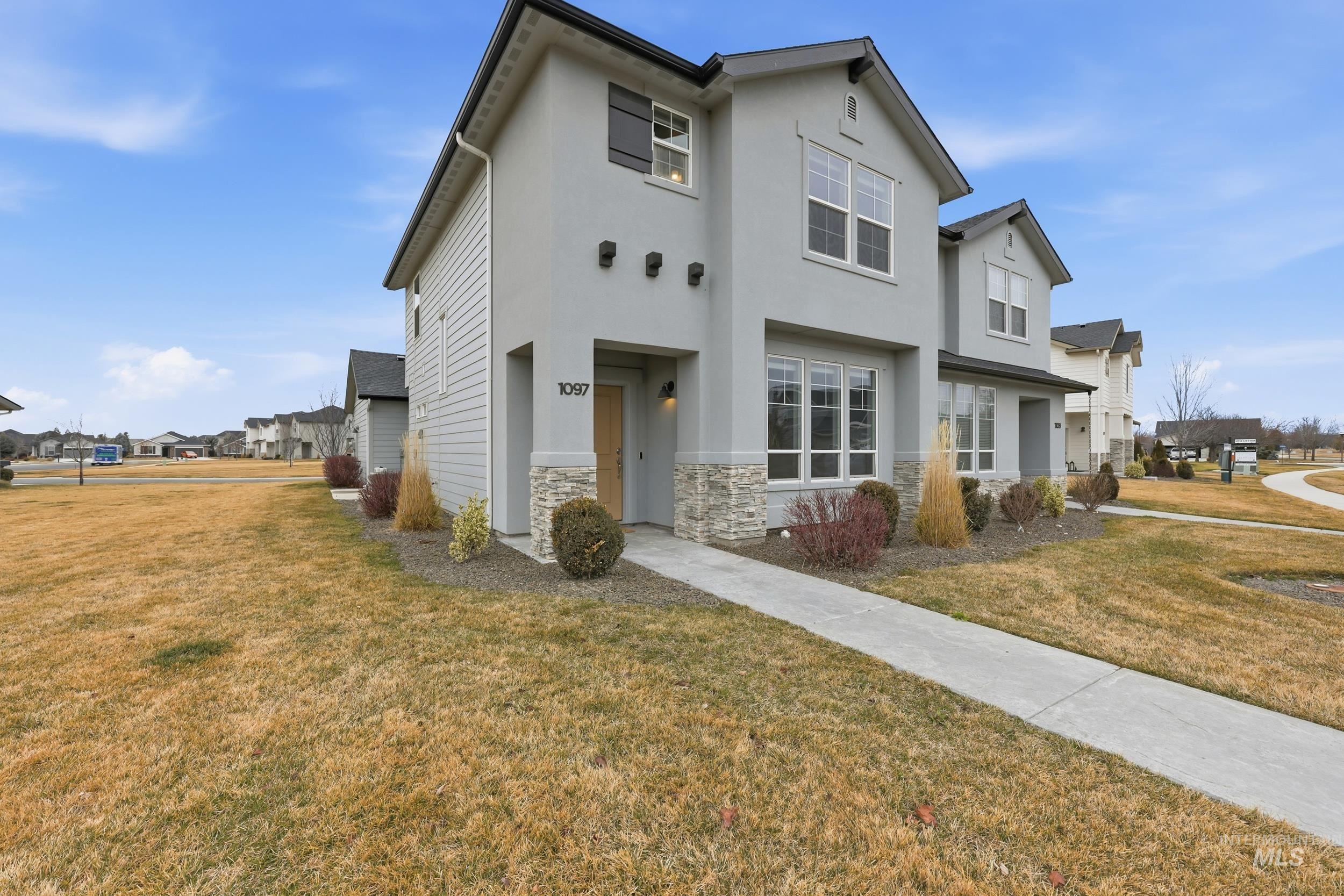1097 North World Cup Lane Eagle, ID 83616 - Photo 1 of 42 View of front of property featuring stone siding, stucco siding, a front yard, and a residential view