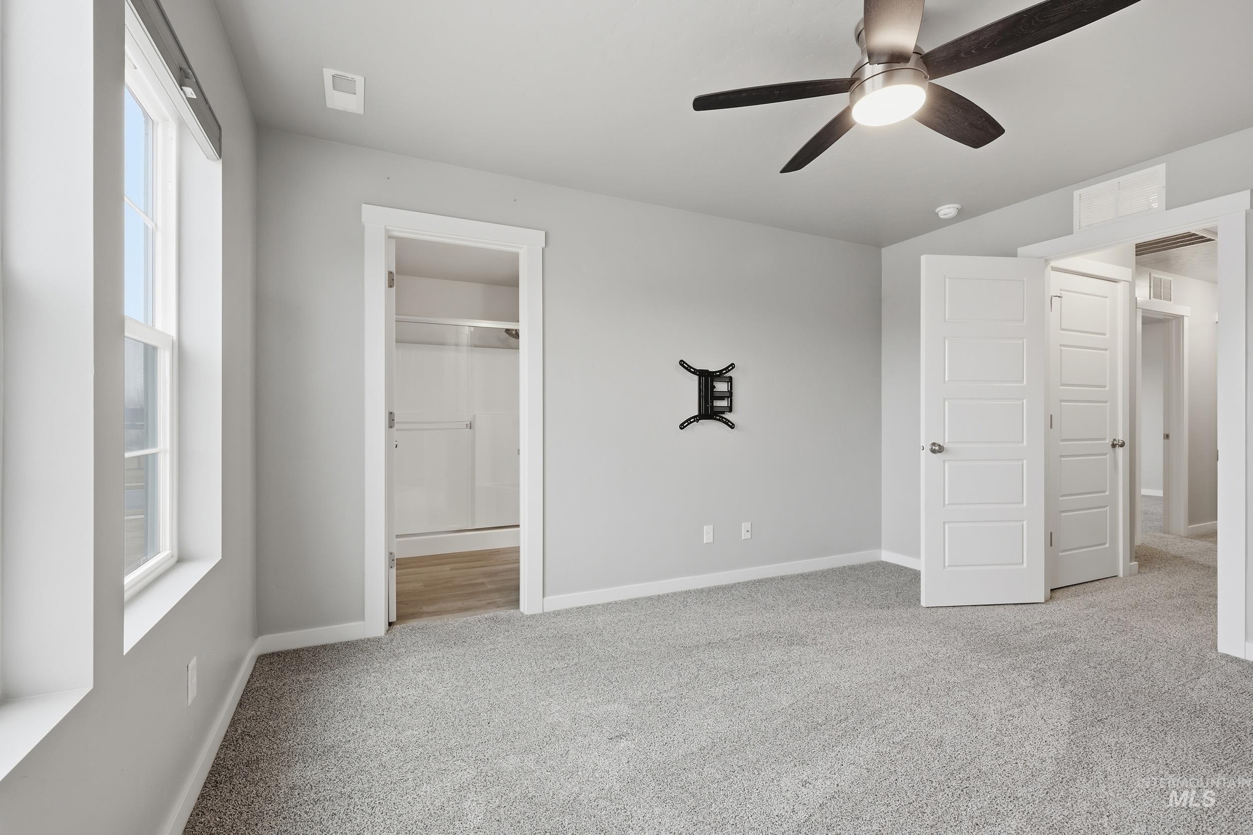 1097 North World Cup Lane Eagle, ID 83616 - Photo 20 of 42 Unfurnished bedroom featuring light colored carpet, a ceiling fan, and connected bathroom