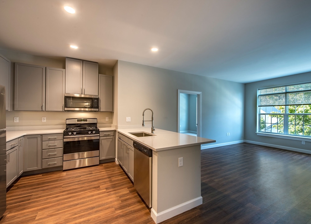 72 Flint Street, Unit 1106 Salem, MA 01970 - Photo 2 of 13 a kitchen with stainless steel appliances granite countertop a stove and a sink