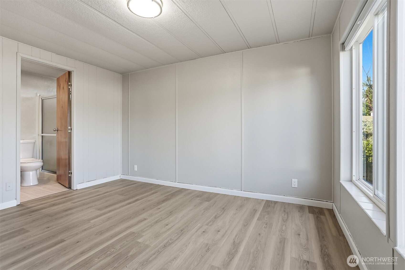 23728 Vista View Avenue Bothell, WA 98021 - Photo 24 of 40 a view of an empty room with wooden floor and a window