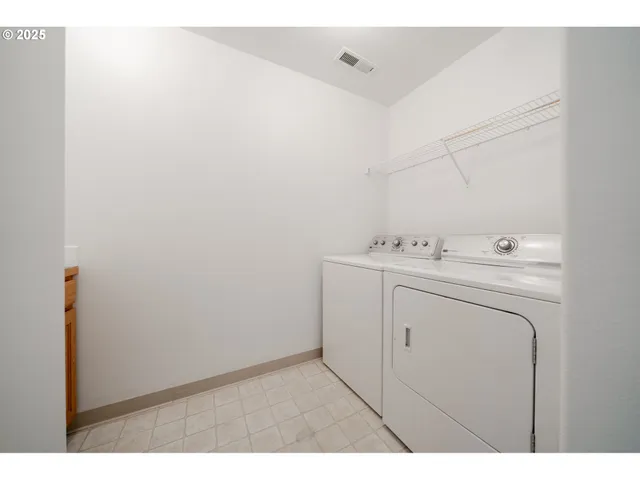 a view of an empty room with wooden floor and a ceiling fan