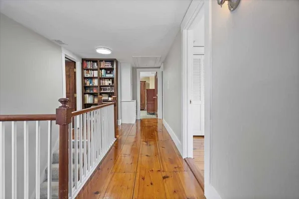 a view of a hallway with wooden floor and entryway