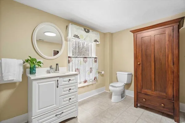 a spacious bathroom with a toilet a sink and a mirror