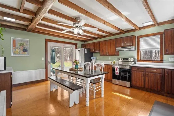 a kitchen with stainless steel appliances granite countertop a stove a sink dishwasher and a refrigerator with wooden floor