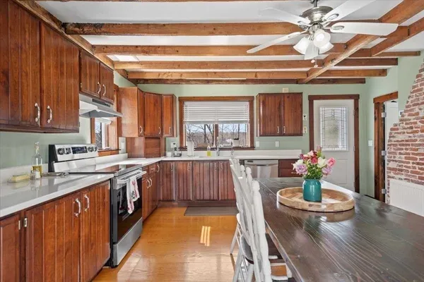 a kitchen with stainless steel appliances granite countertop a sink dishwasher and cabinets with wooden floor
