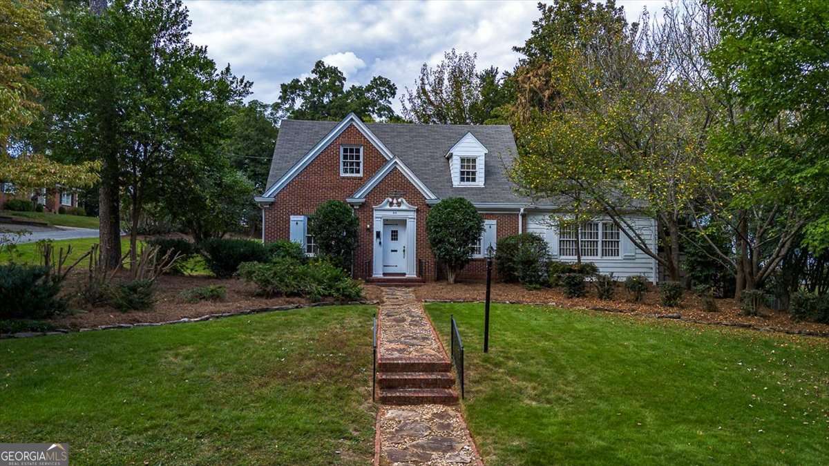 a front view of a house with a yard and garden