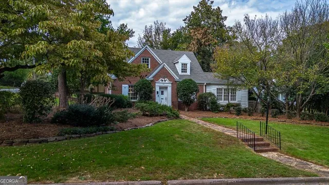a front view of a house with a yard and trees