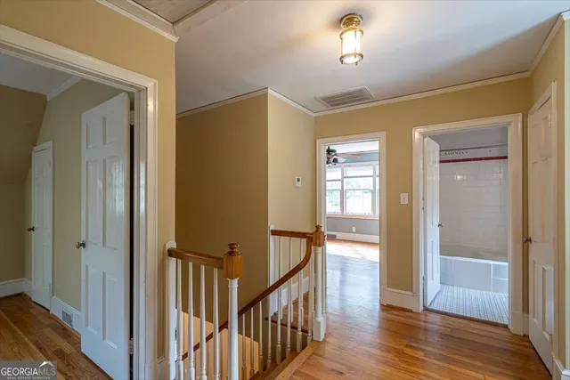 a view of a hallway with wooden floor and staircase