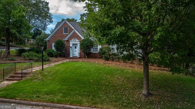 a front view of a house with yard and green space