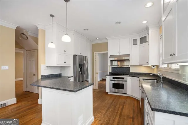 a kitchen with stainless steel appliances granite countertop a sink refrigerator and microwave
