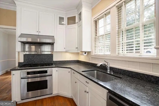 a kitchen with granite countertop a stove and a sink