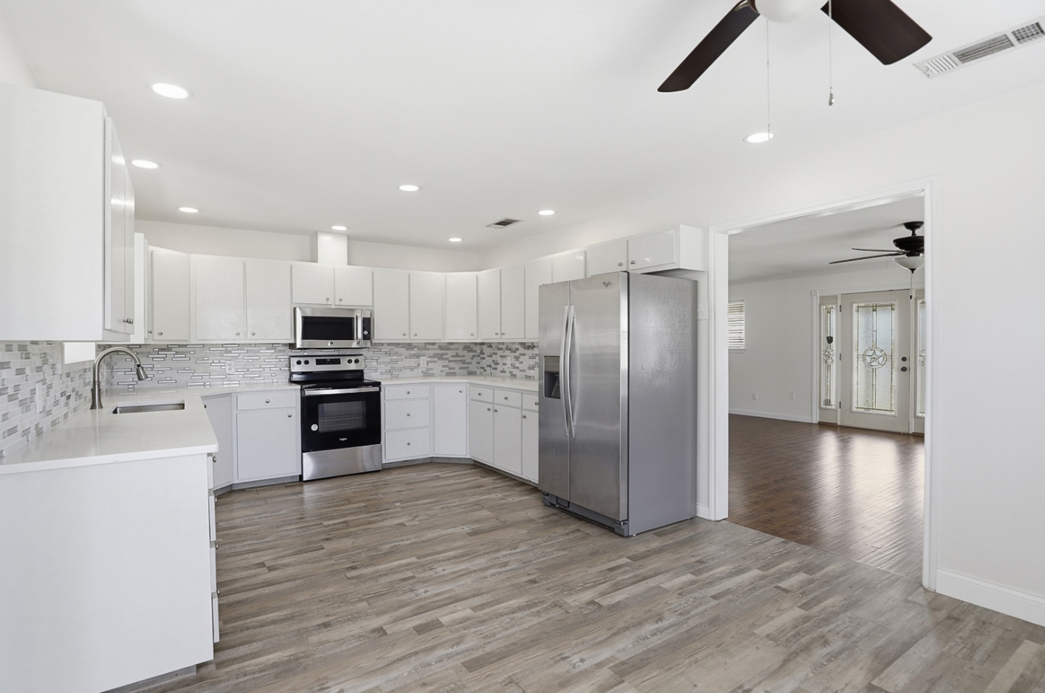 128 Skyview Terrace Leander, TX 78641 - Photo 7 of 23 Kitchen with stainless steel appliances, white cabinets, backsplash, and recessed lighting