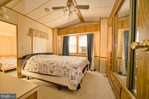 a bedroom with a large bed and two large window