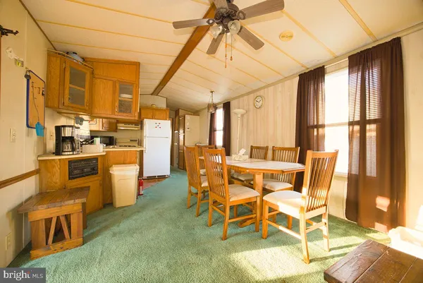 a dining room with stainless steel appliances kitchen island granite countertop furniture and a window