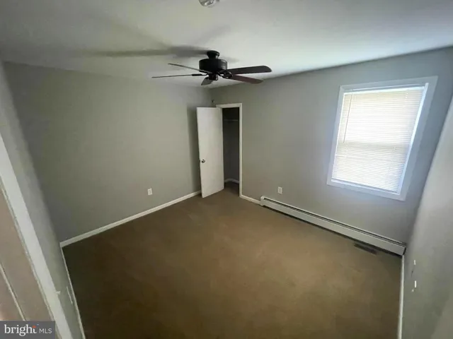 an empty room with a window and a fan