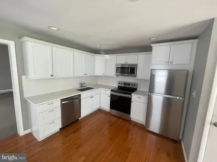 a kitchen with a refrigerator stove and white cabinets