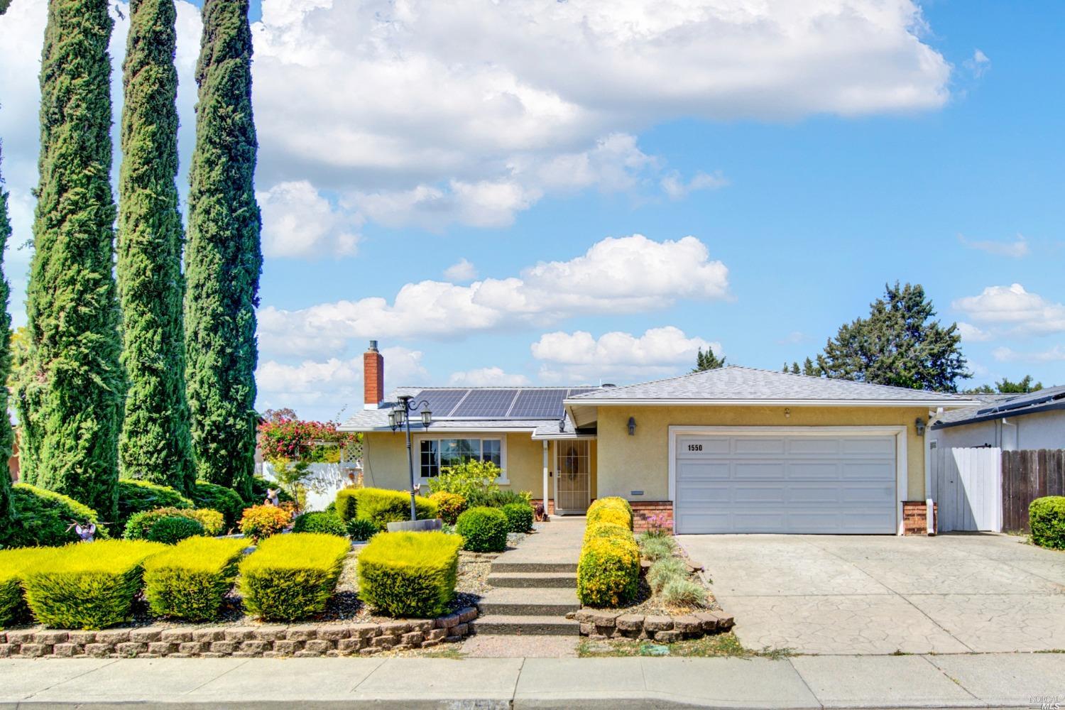 a front view of a house with a garden and yard