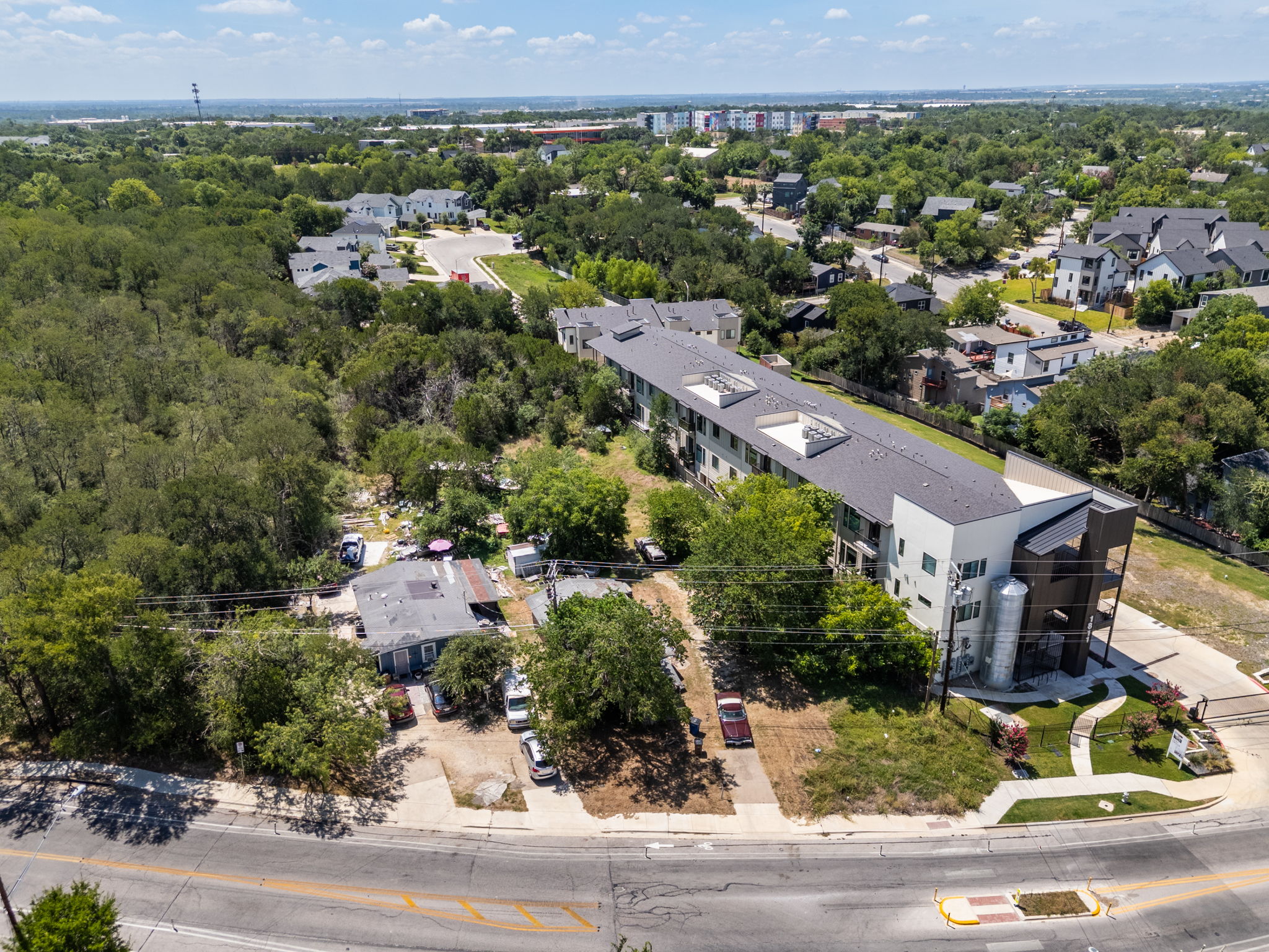 1813 Webberville Road Austin, TX 78721 - Photo 18 of 20 An aerial perspective reveals a vibrant neighborhood with residential buildings nestled among lush green trees.