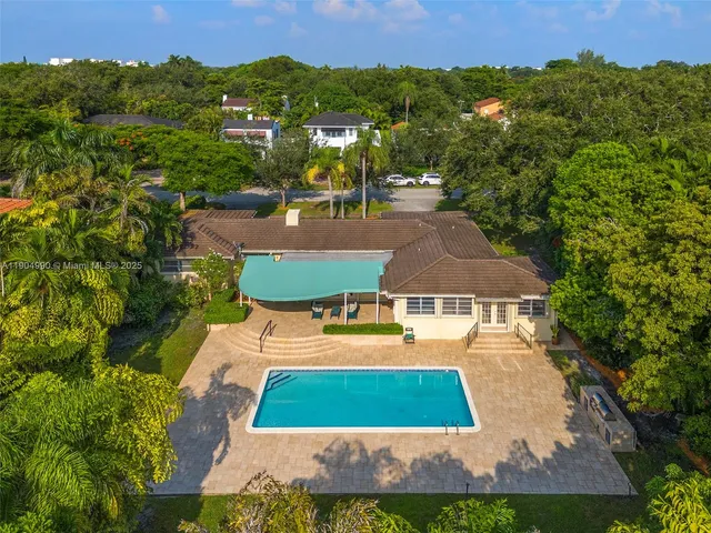 an aerial view of residential houses with outdoor space and trees