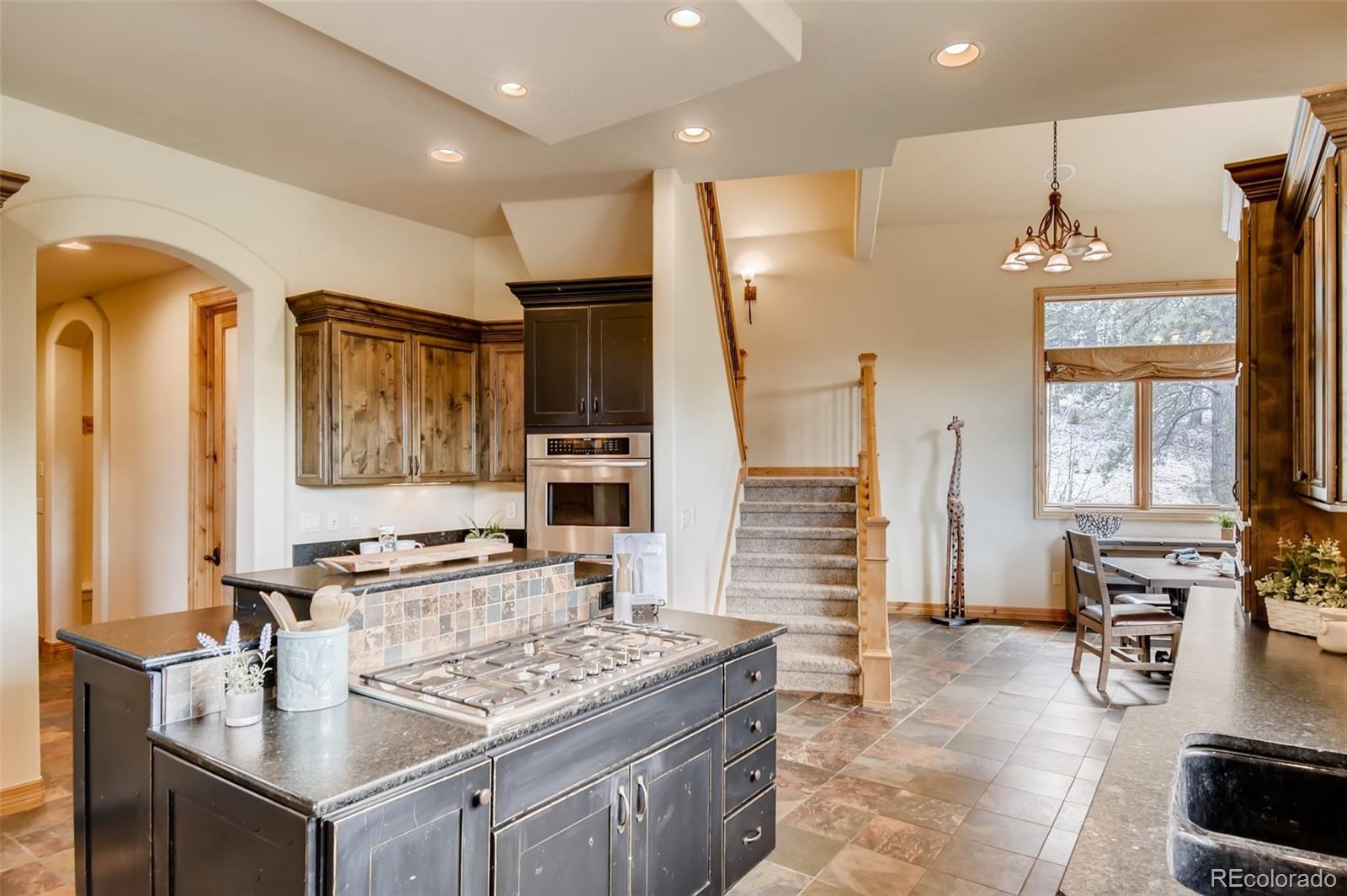 1265 Silver Rock Lane Evergreen, CO 80439 - Photo 12 of 35 a kitchen with stainless steel appliances granite countertop a stove and a refrigerator