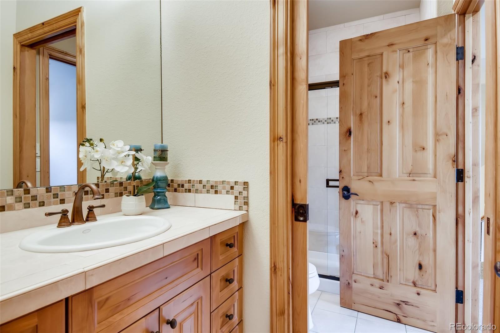 1265 Silver Rock Lane Evergreen, CO 80439 - Photo 20 of 35 a bathroom with a sink and a mirror
