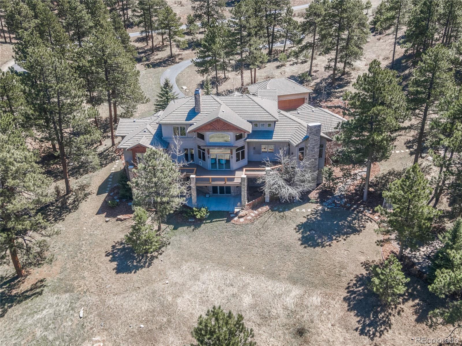 1265 Silver Rock Lane Evergreen, CO 80439 - Photo 32 of 35 an aerial view of a house with a yard and large trees