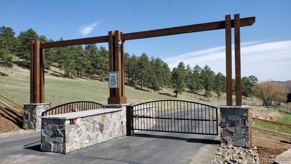 1265 Silver Rock Lane Evergreen, CO 80439 - Photo 35 of 35 a view of a porch with a floor to ceiling window wooden floor and fence