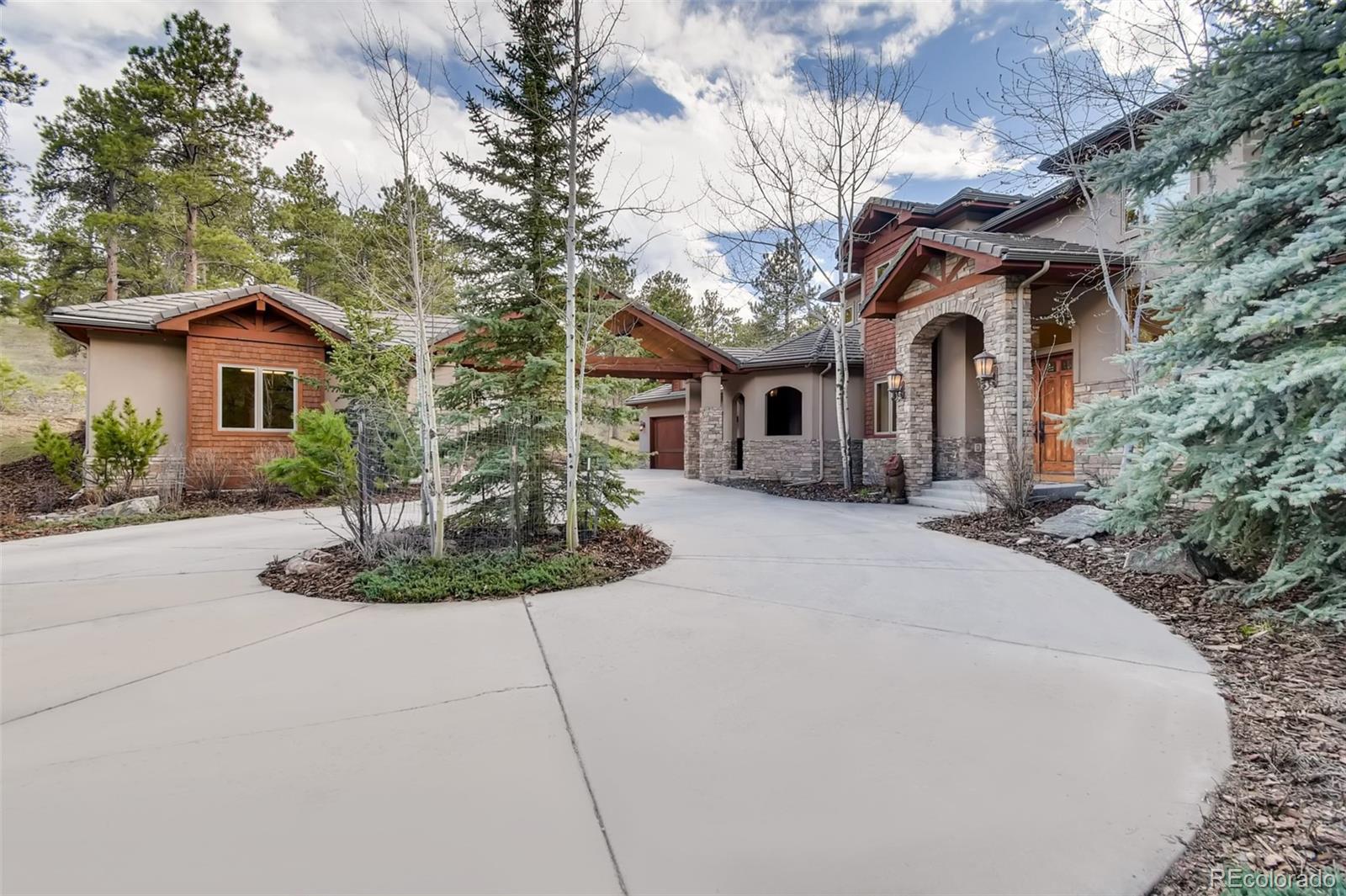 1265 Silver Rock Lane Evergreen, CO 80439 - Photo 4 of 35 a front view of a house with garden