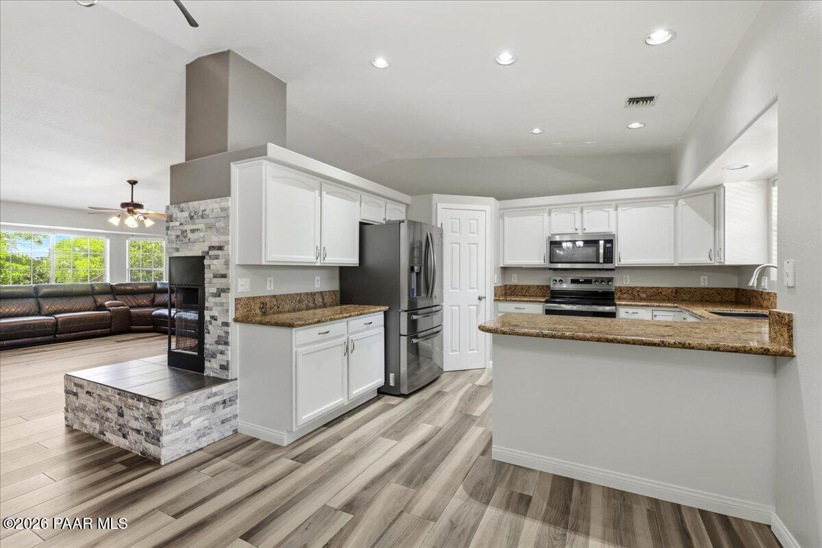 4701 North Spring Drive Prescott Valley, AZ 86314 - Photo 12 of 31 a kitchen with stainless steel appliances granite countertop a stove top oven a sink dishwasher a refrigerator and white cabinets with wooden floor
